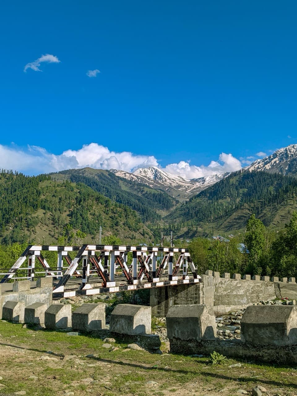 A bridge below snow-capped peaks on the way to Sonamarg